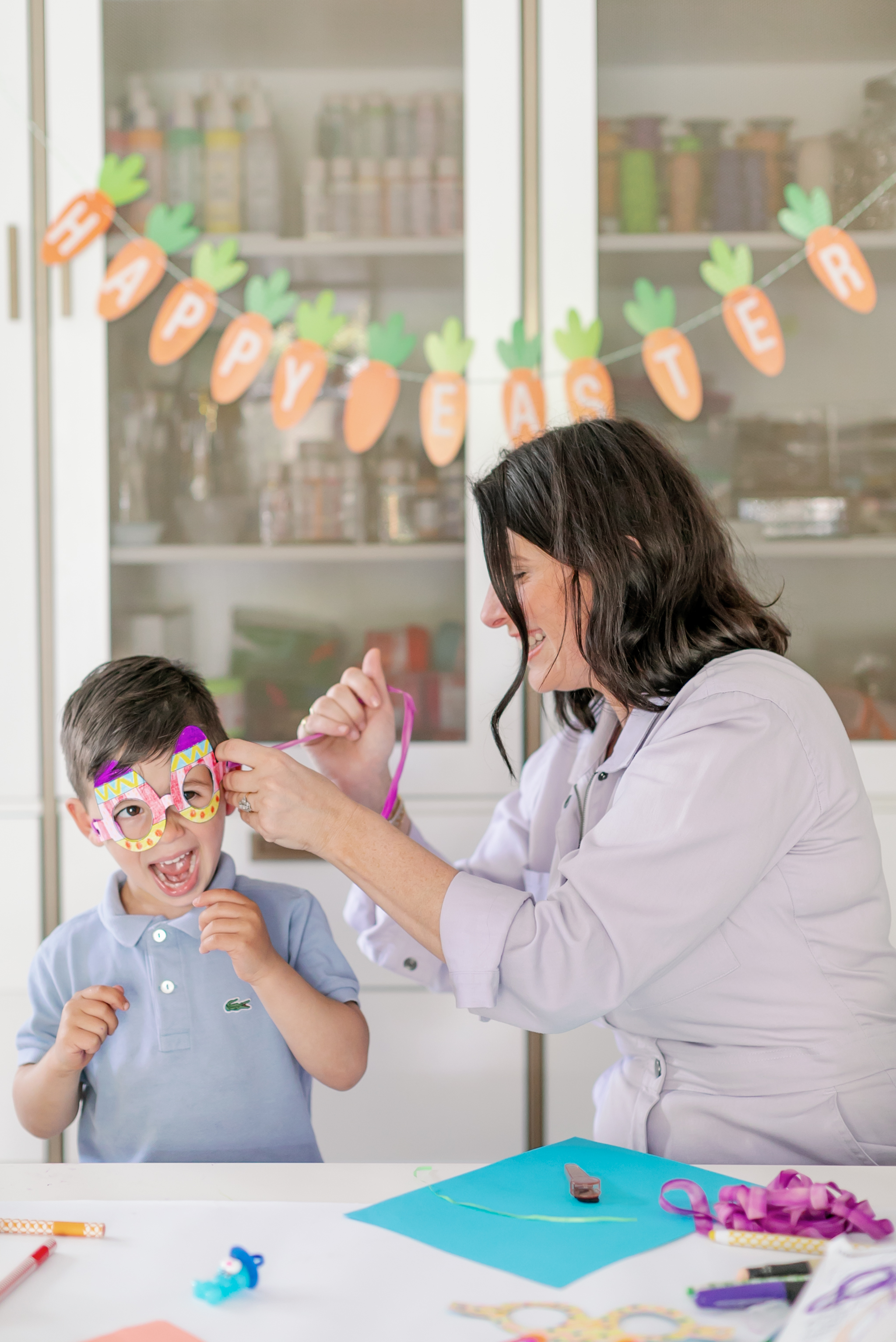 Erica putting a pair of Easter glasses on her son.