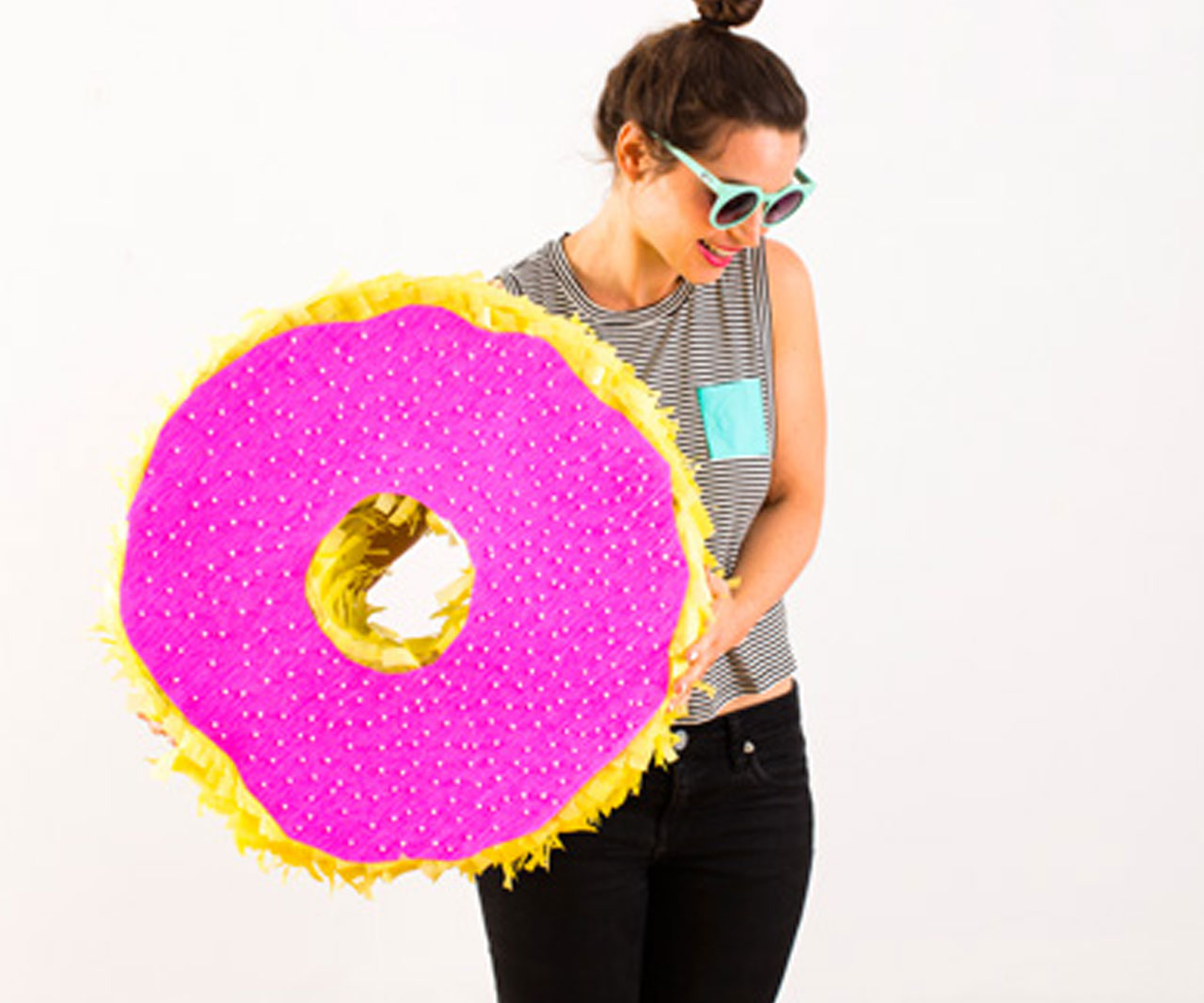 Person holding a donut-shaped piñata.