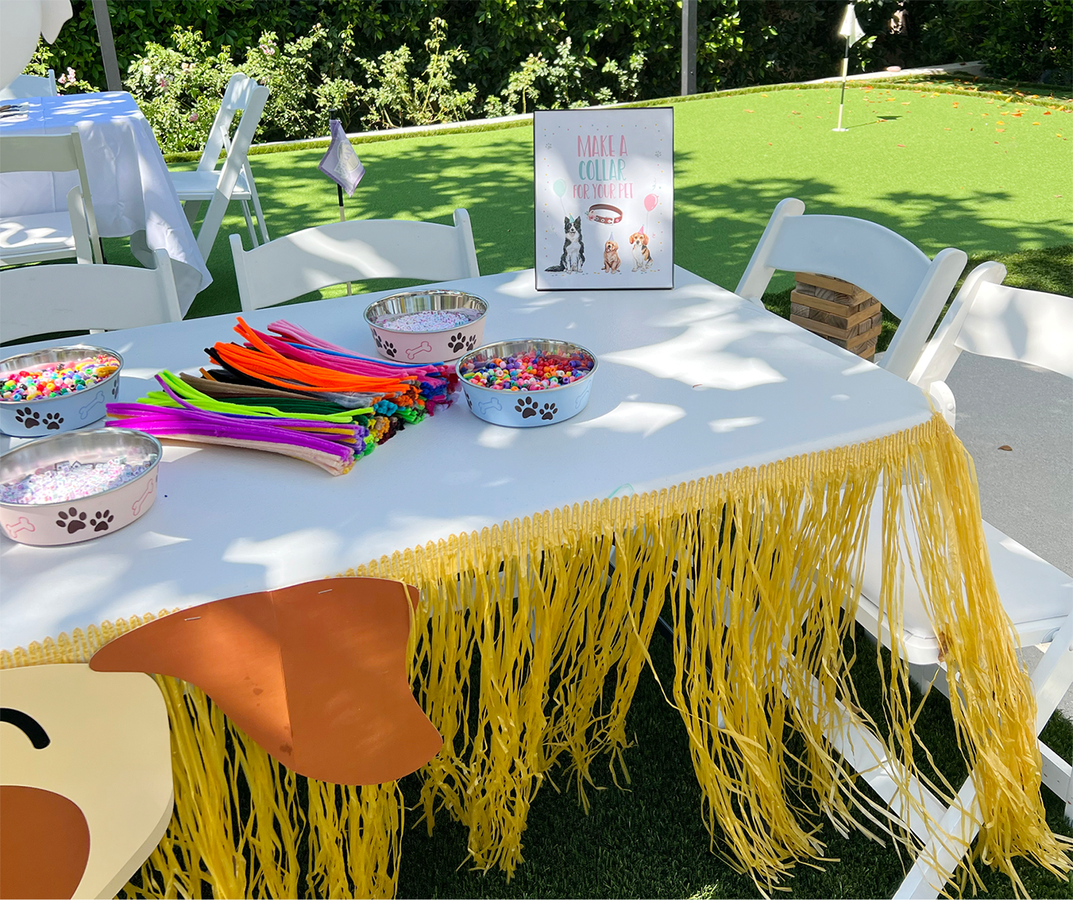 Table set up with dog bowls filled with pompoms for crafting.