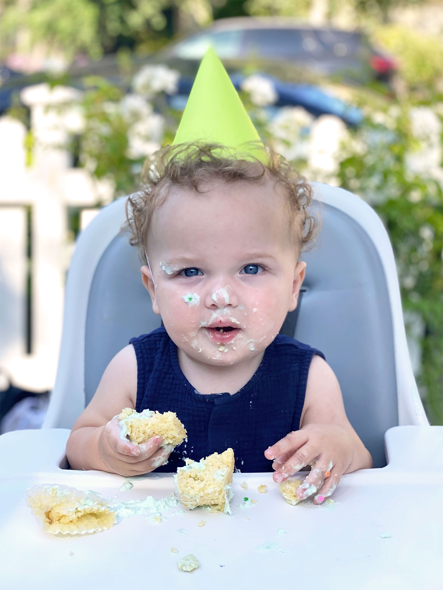 Child eating cake while wearing a party hat.
