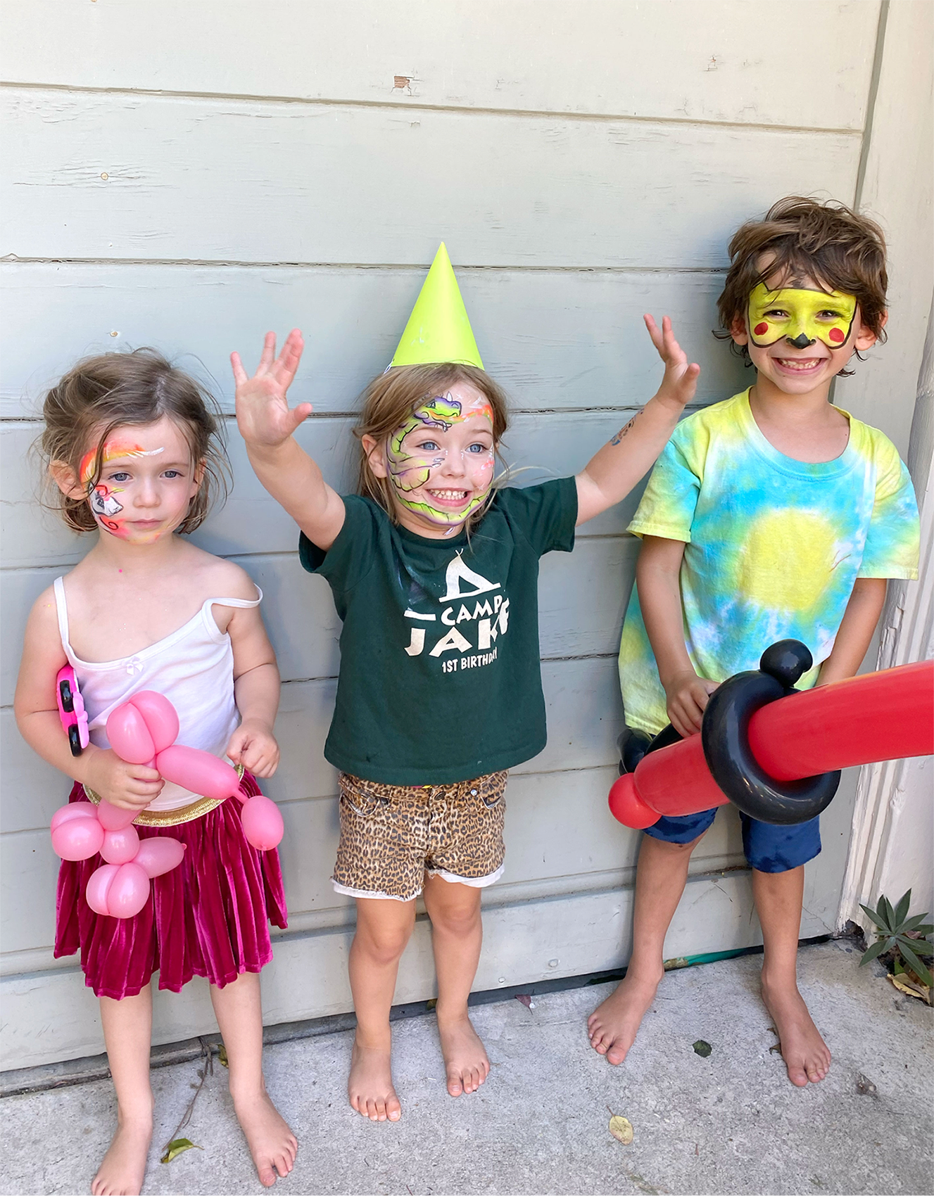 Kids with painted faces posing together.