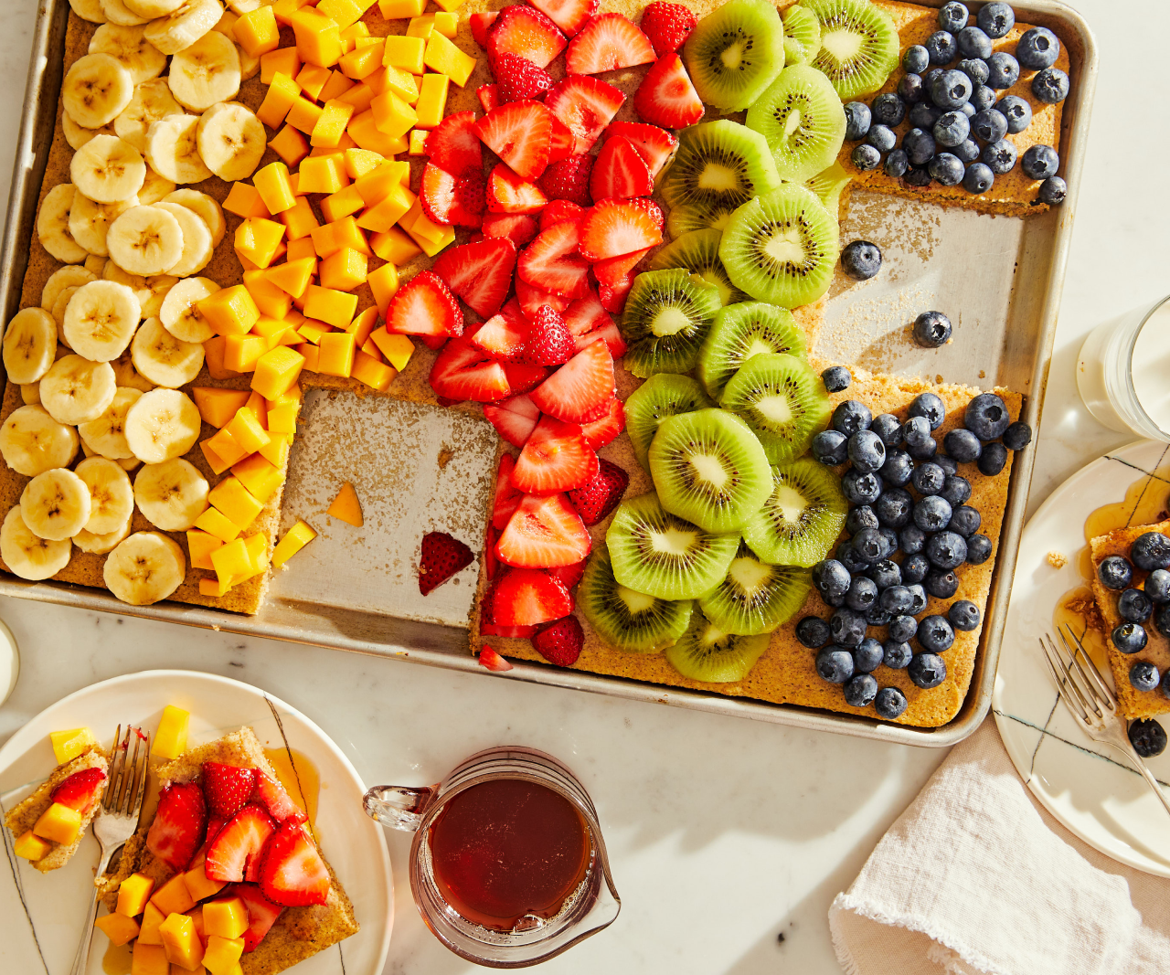 Overhead shot of a large pancake covered in colorful fruit.