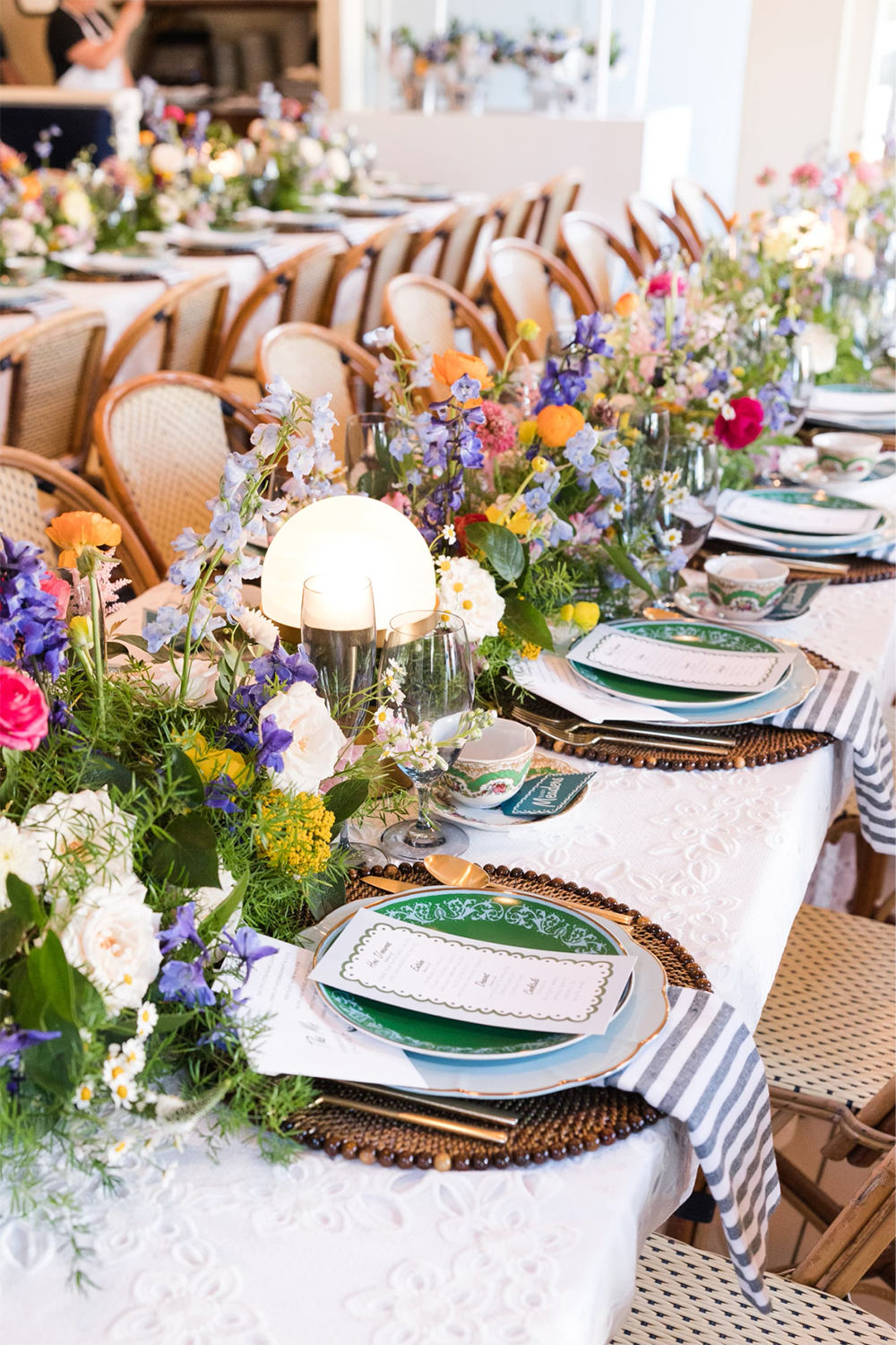 A table set with plates and colorful flowers.