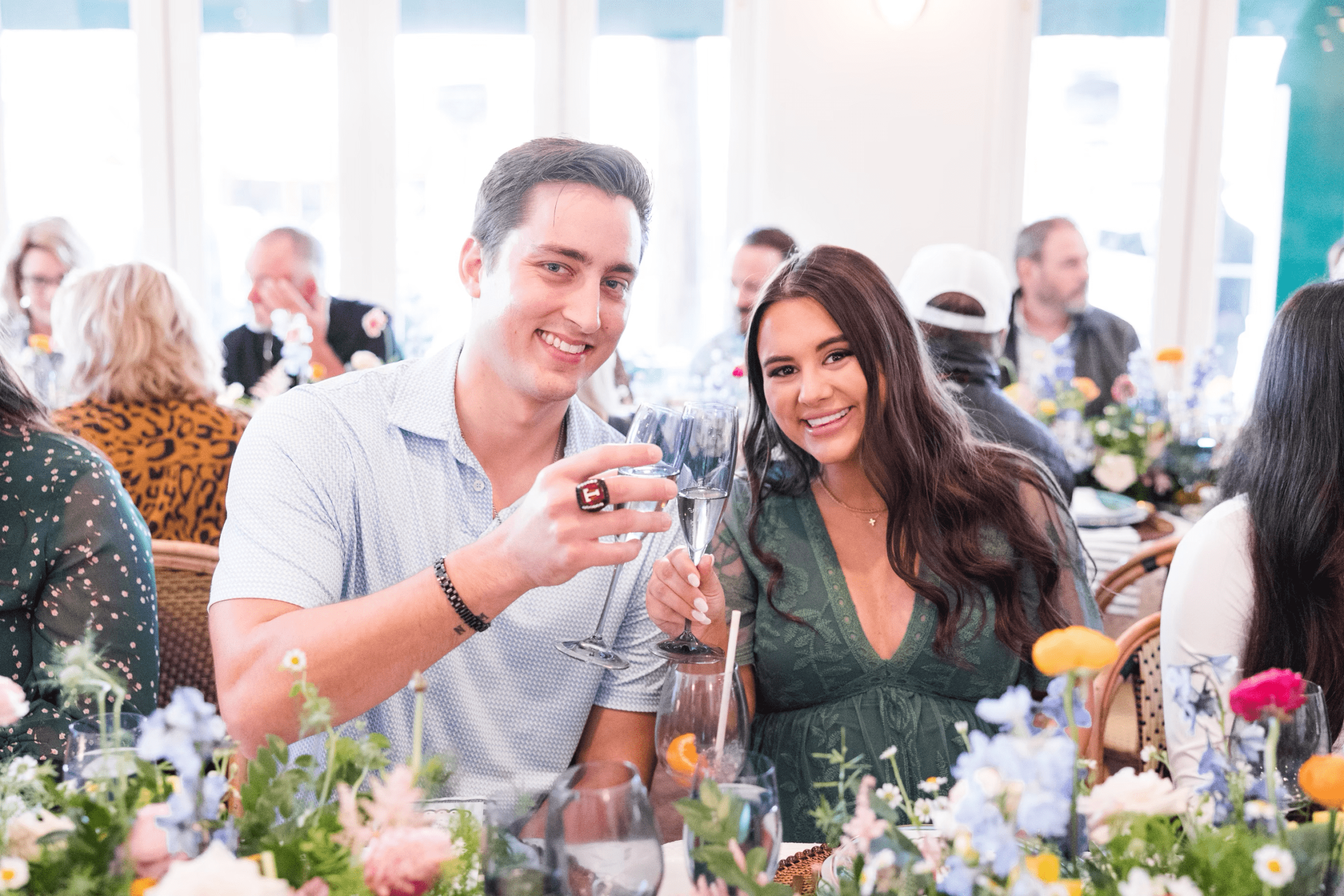 A couple smiling and clinking their glasses.
