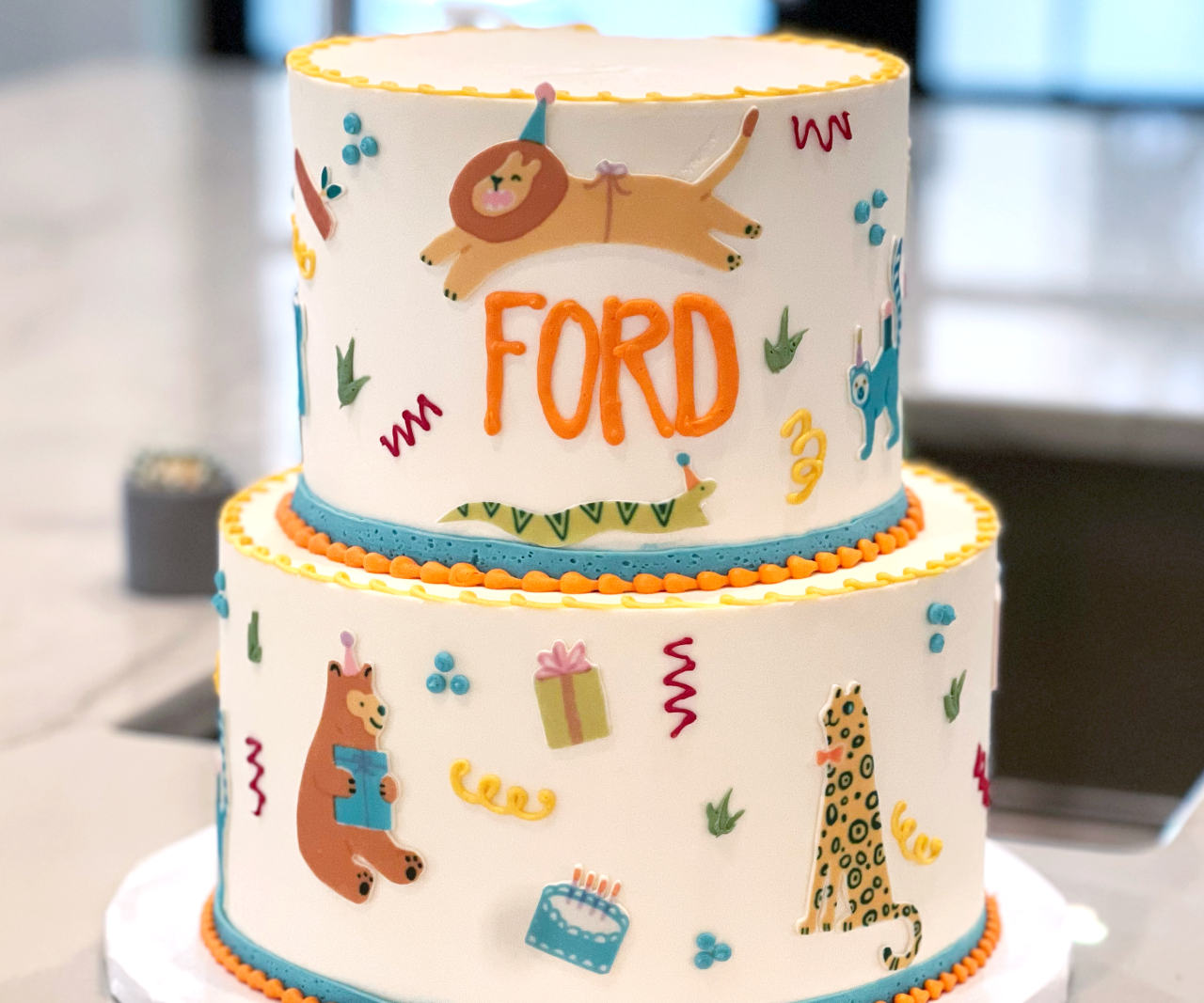 A two-tiered animal-themed birthday cake.