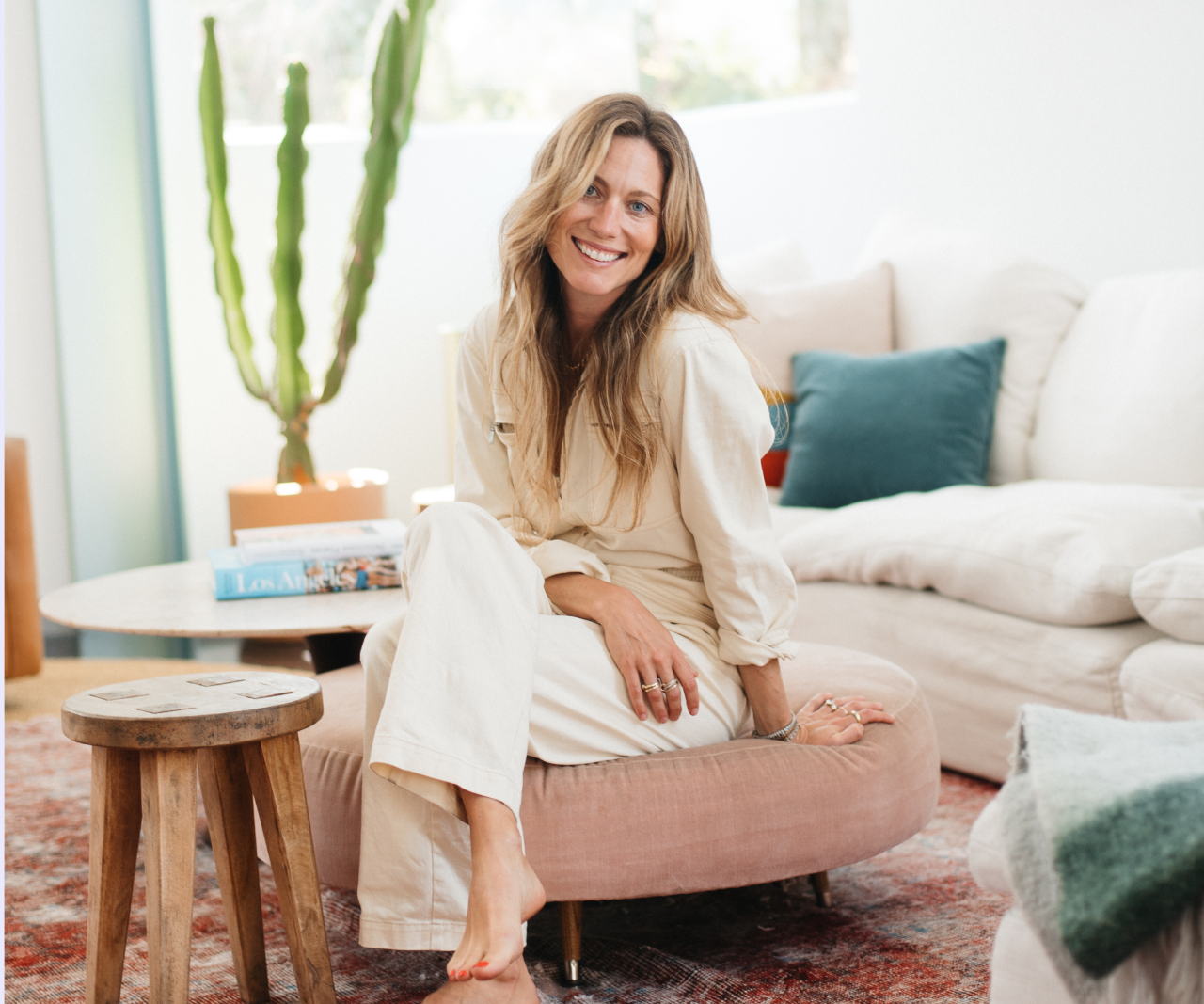 Mia Rigden sitting on an ottoman and smiling.