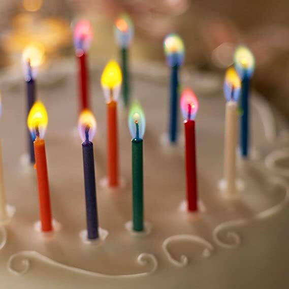 A close-up of multi-color birthday candles.