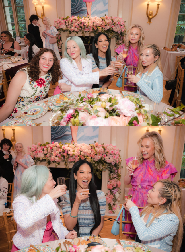Women at table clinking glasses and smiling.