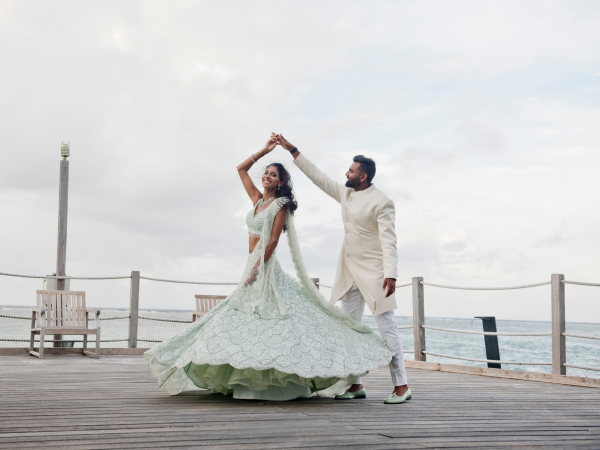 Priya and Sumanth dancing on a pier.