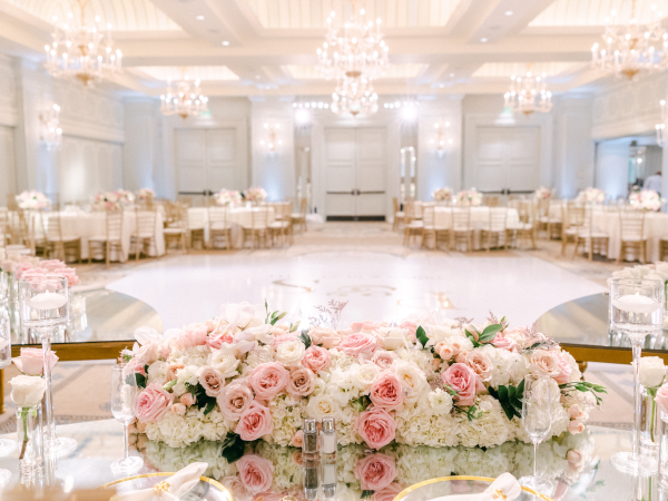 The venue full of tables, chandeliers and flowers.