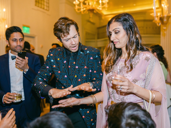 A magician performing magic over a woman's hand.