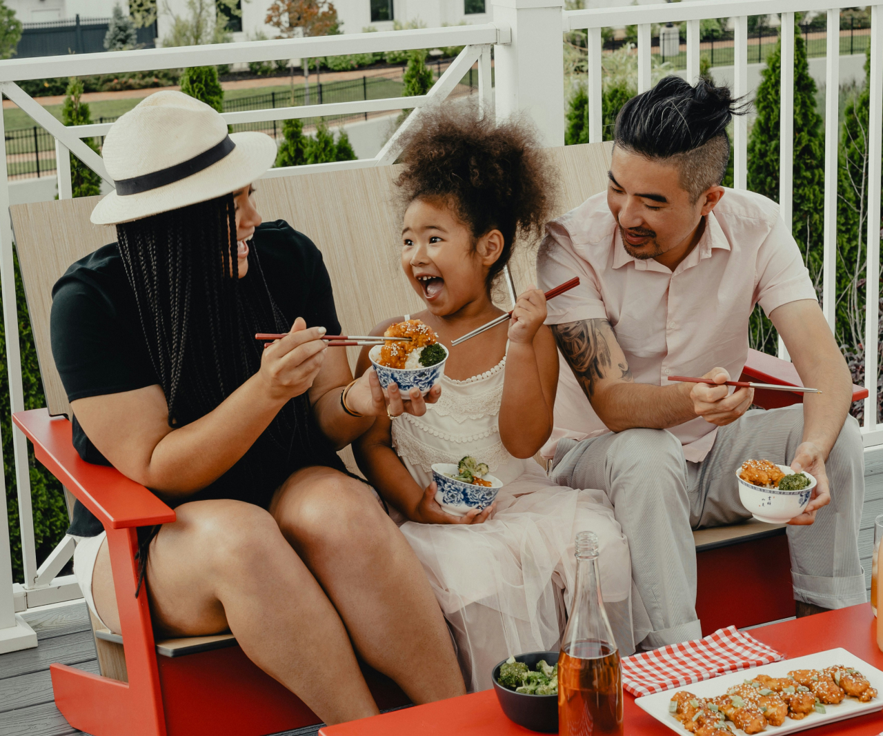 Family making and eating a meal together outside.