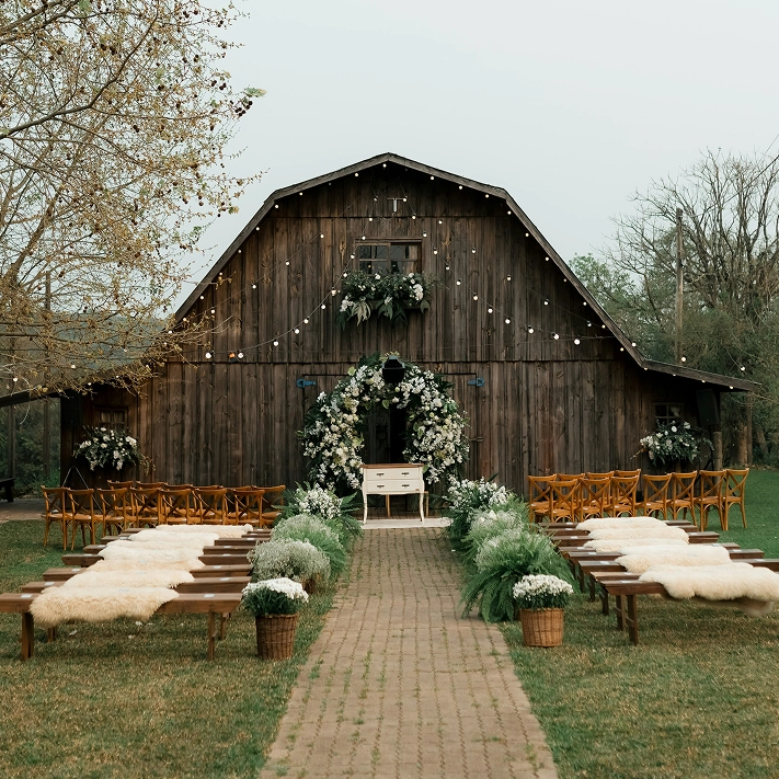 Photo of the front of a barn decorated for a wedding ceremony.