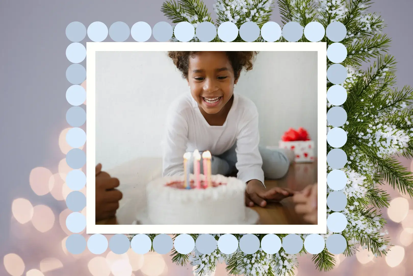 Child smiling at a birthday cake with lit candles, framed by a winter border with snowy pine branches and a ring of pale blue circles.