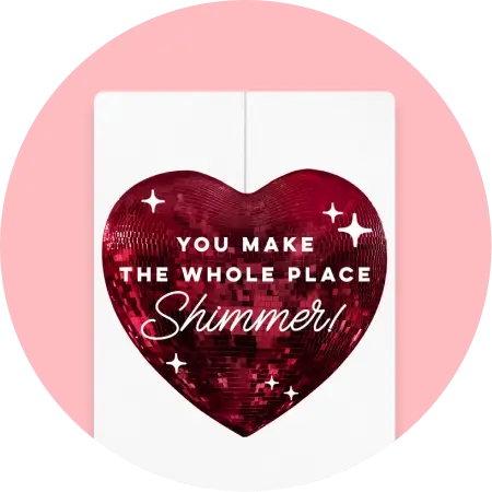A white invitation with a sparkly red heart on it with 'You Make The Whole Place Shimmer!' 