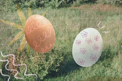Two hand-painted Easter eggs over a grassy field, with playful pink and yellow doodles.