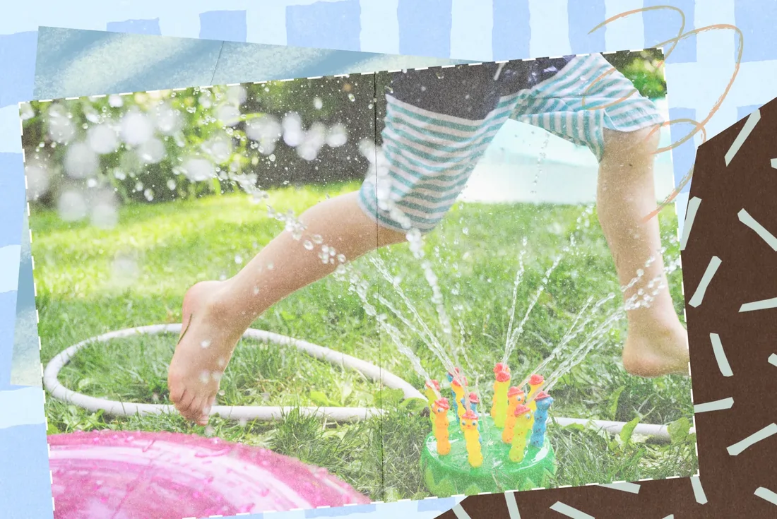 Child with striped shorts jumping over a sprinkler spraying water in a grassy yard.