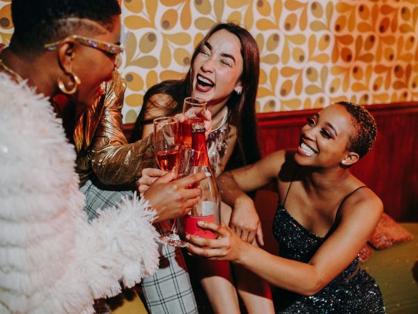 A group of women drinking rose together and laughing.