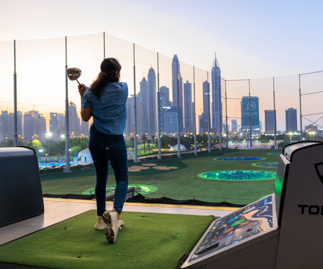 A woman playing golf at Topgolf.