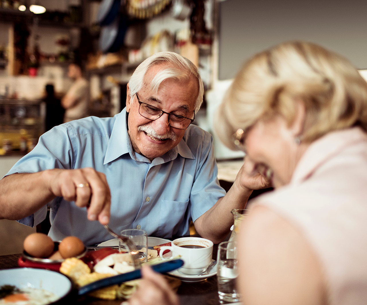 A couple laughed together while eating at a restaurant.