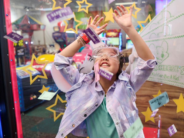 A child gathering tickets in Chuck E. Cheese's Ticket Blaster.