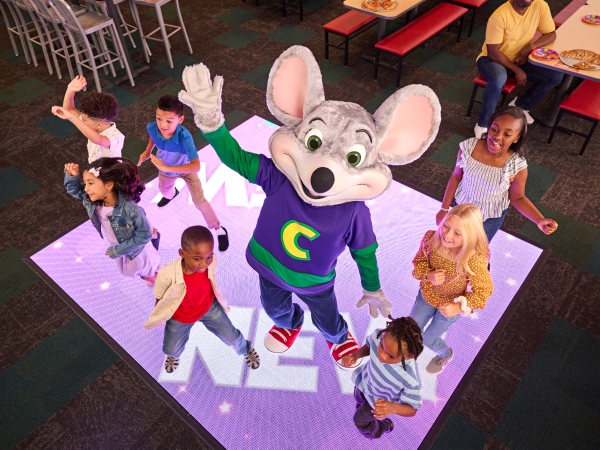 Kids dancing with Chuck E. Cheese.