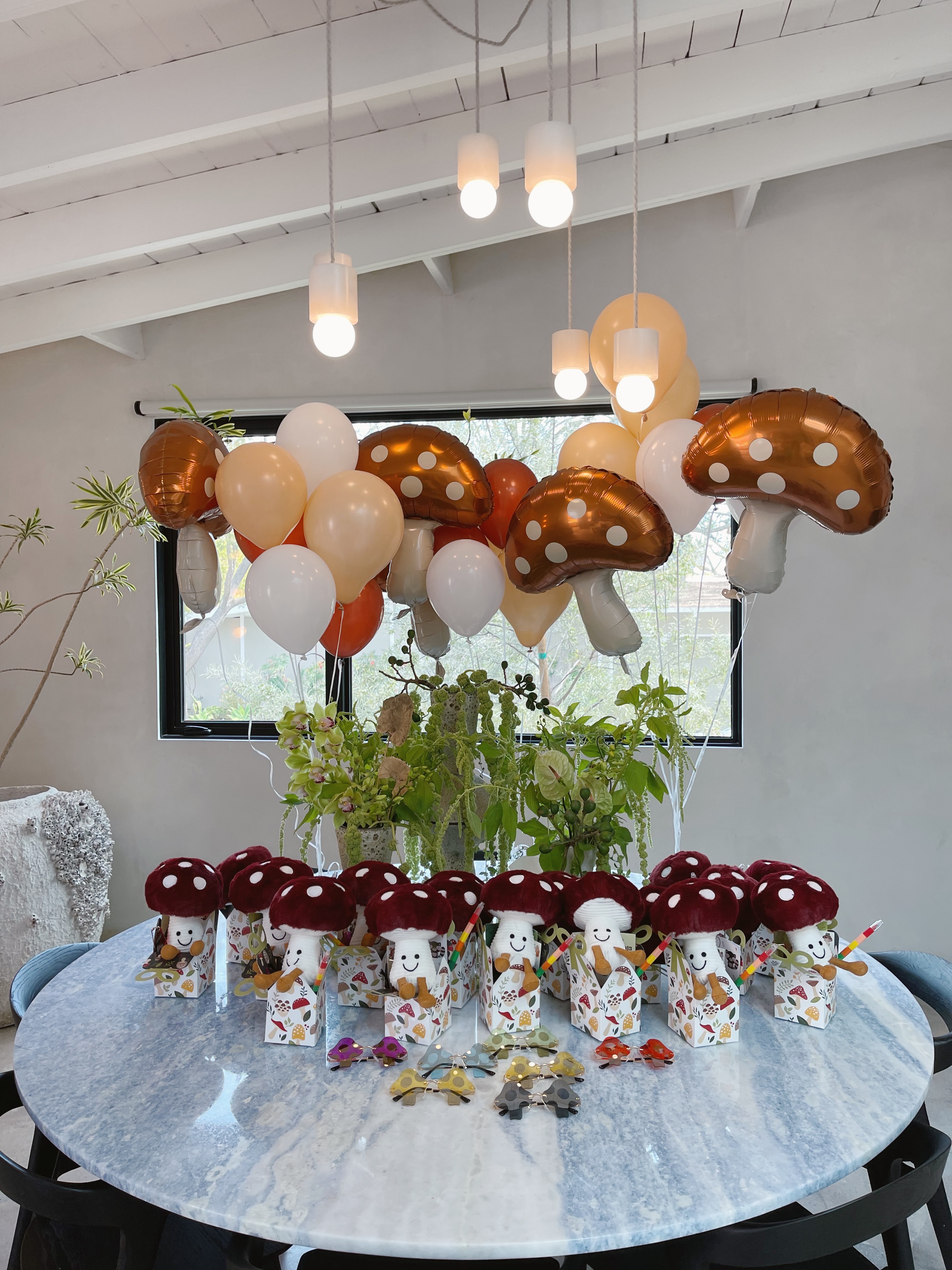 Mushroom plushies poking out of goodie bags with mushroom balloons in the background..