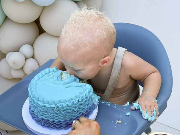 A child biting into a birthday cake.