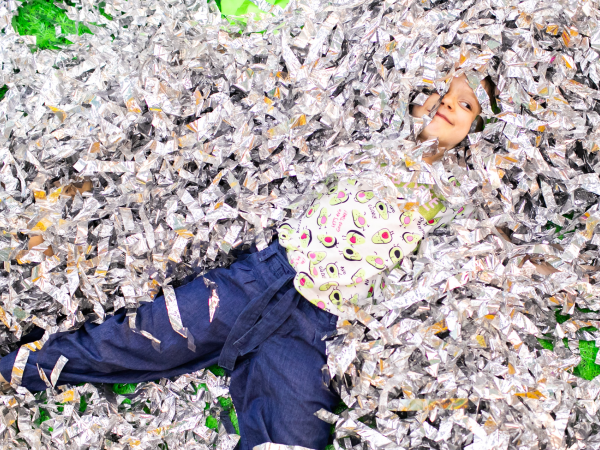 A kid in a pile of tinsel.