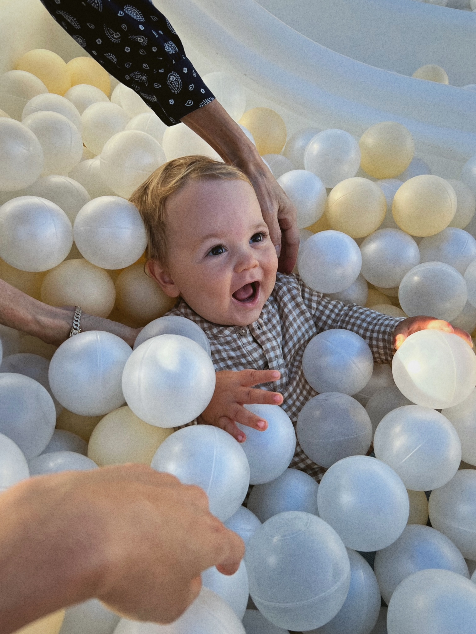A baby boy in a ball pit.