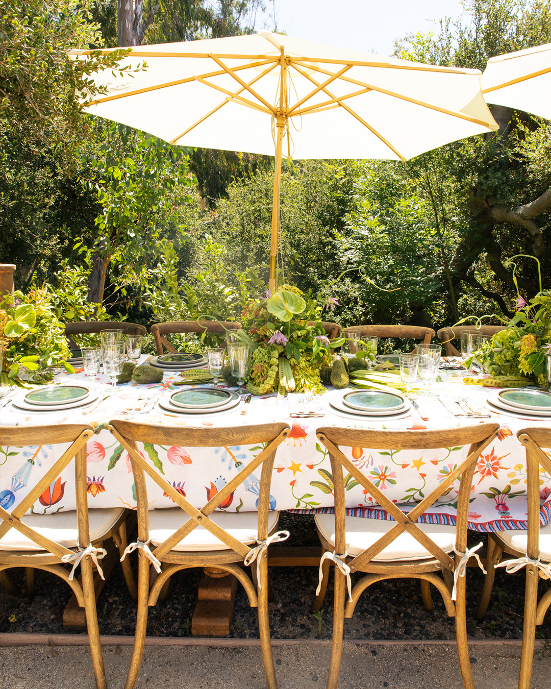 Outdoor table with green florals and white umbrellas.