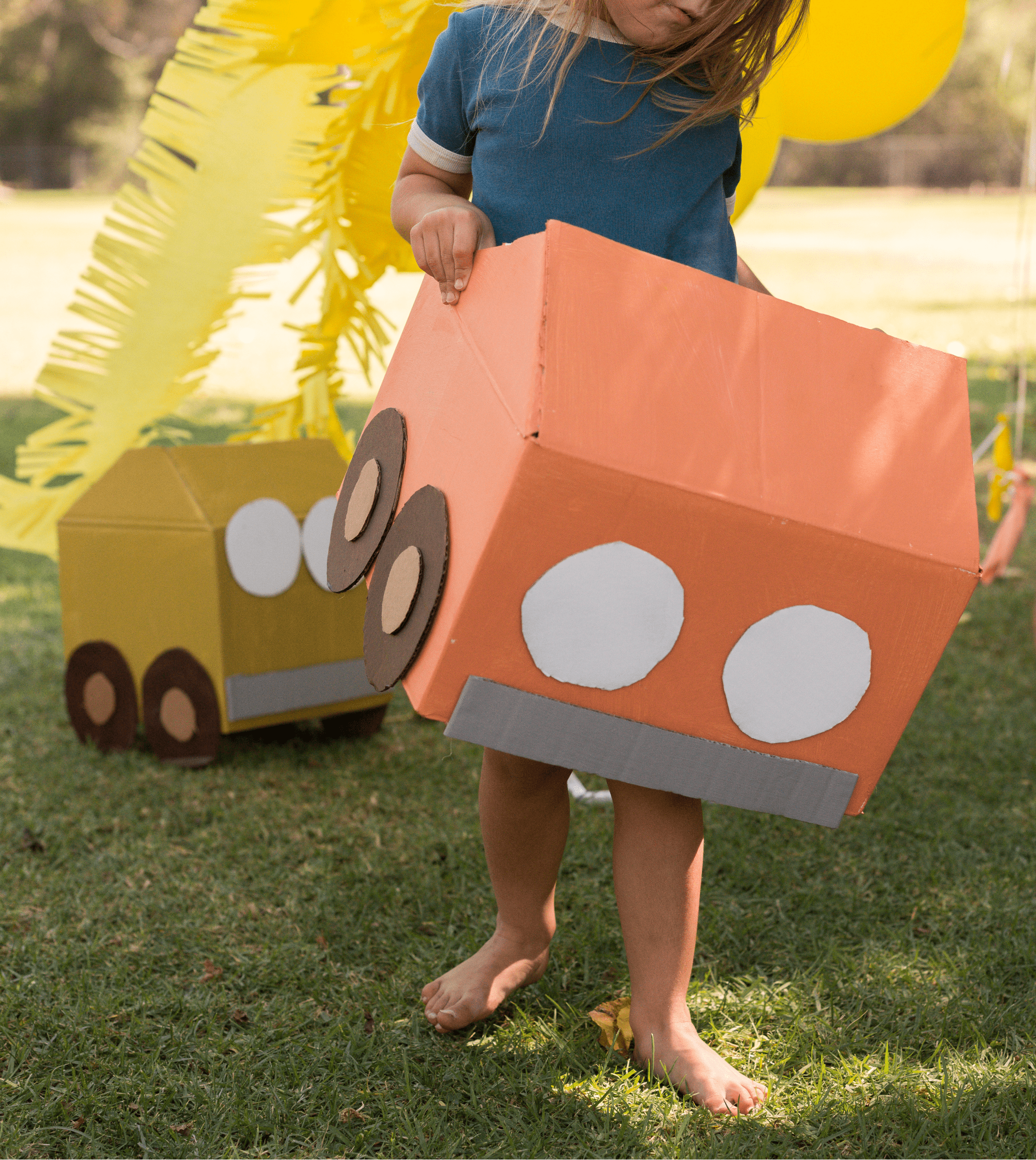 A kid in a cardboard car.