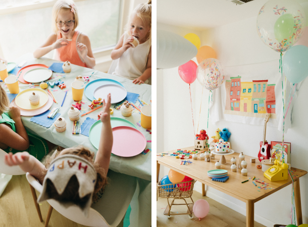 Kids laughing and eating at a birthday party next to a Sesame Street-themed table.